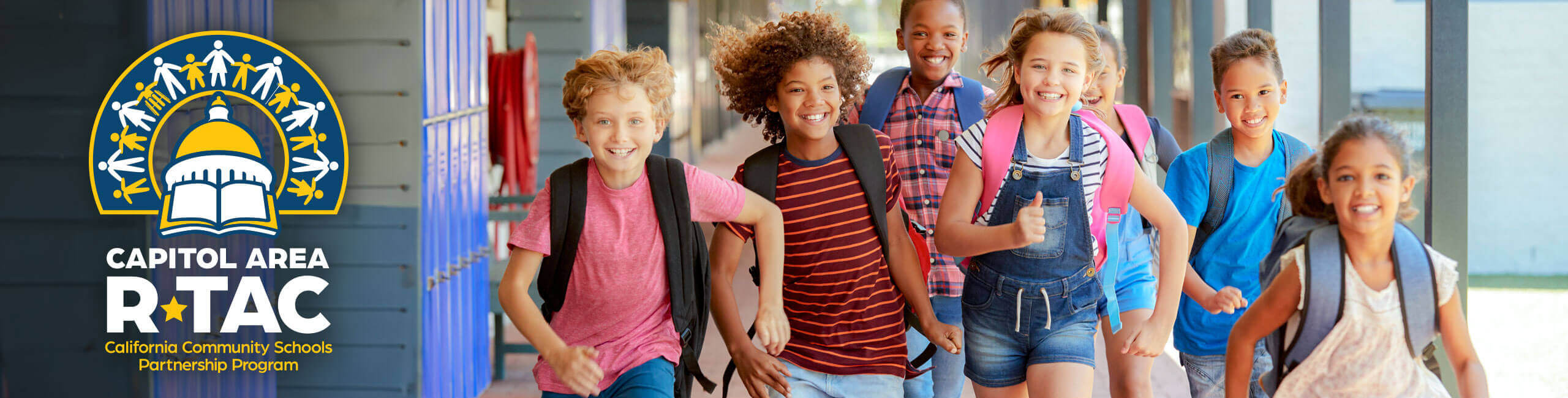 A group of school kids running through school hallway.