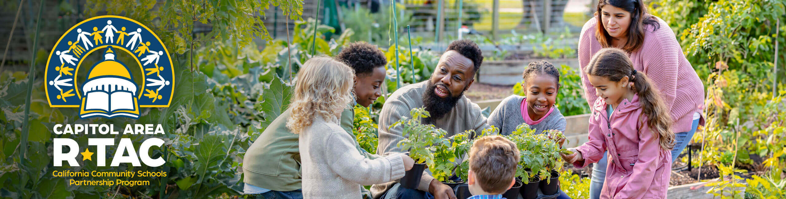 A pair of teachers in a garden teach young kids how to grow vegetables.
